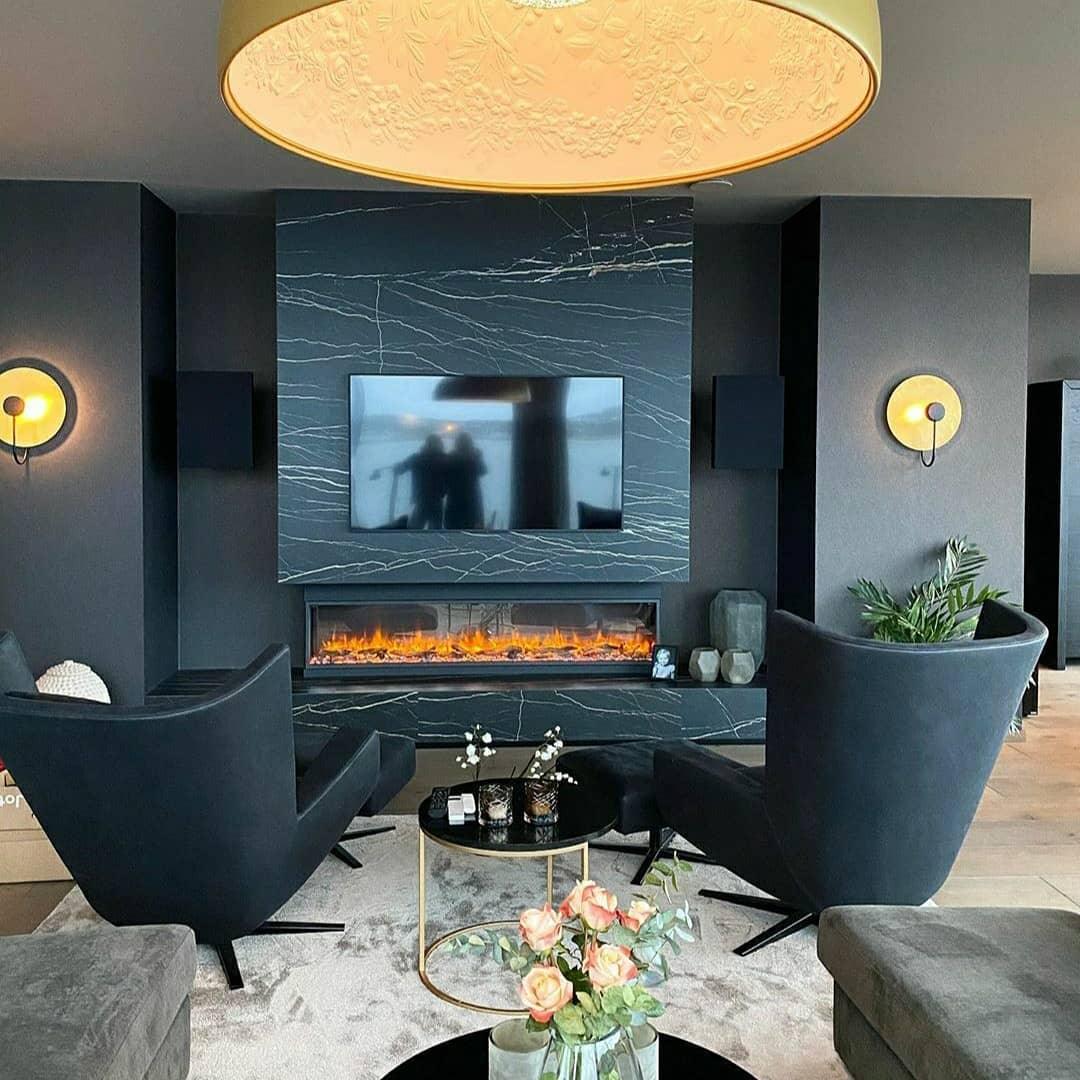 A living room with a fireplace set into a dark stone wall