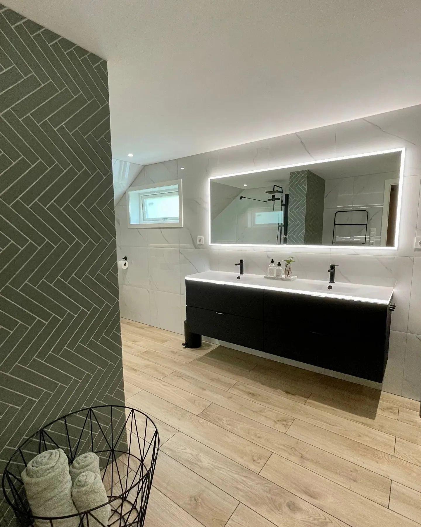 A long vanity under a lit mirror