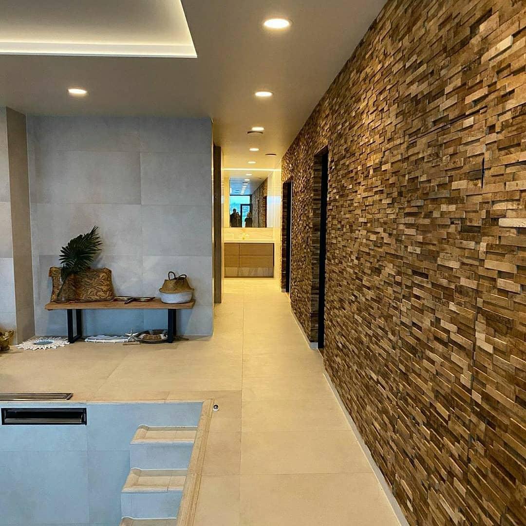 A hallway with one wall clad in natural stone